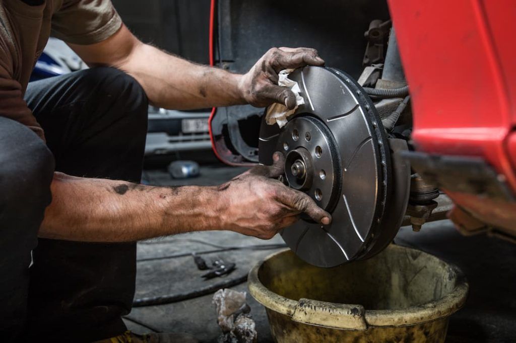 a man cleaning a disc brake